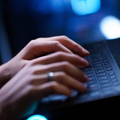 A closeup of hands on a keyboard.