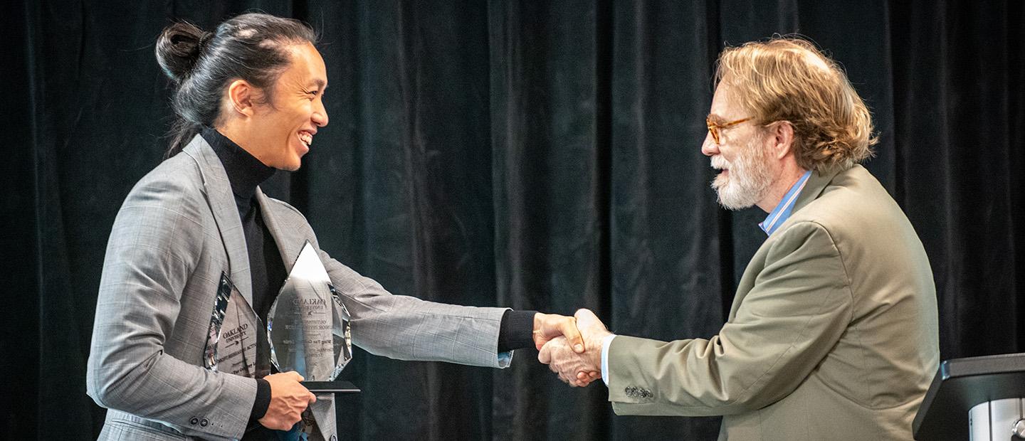 A man presenting an award to another person.